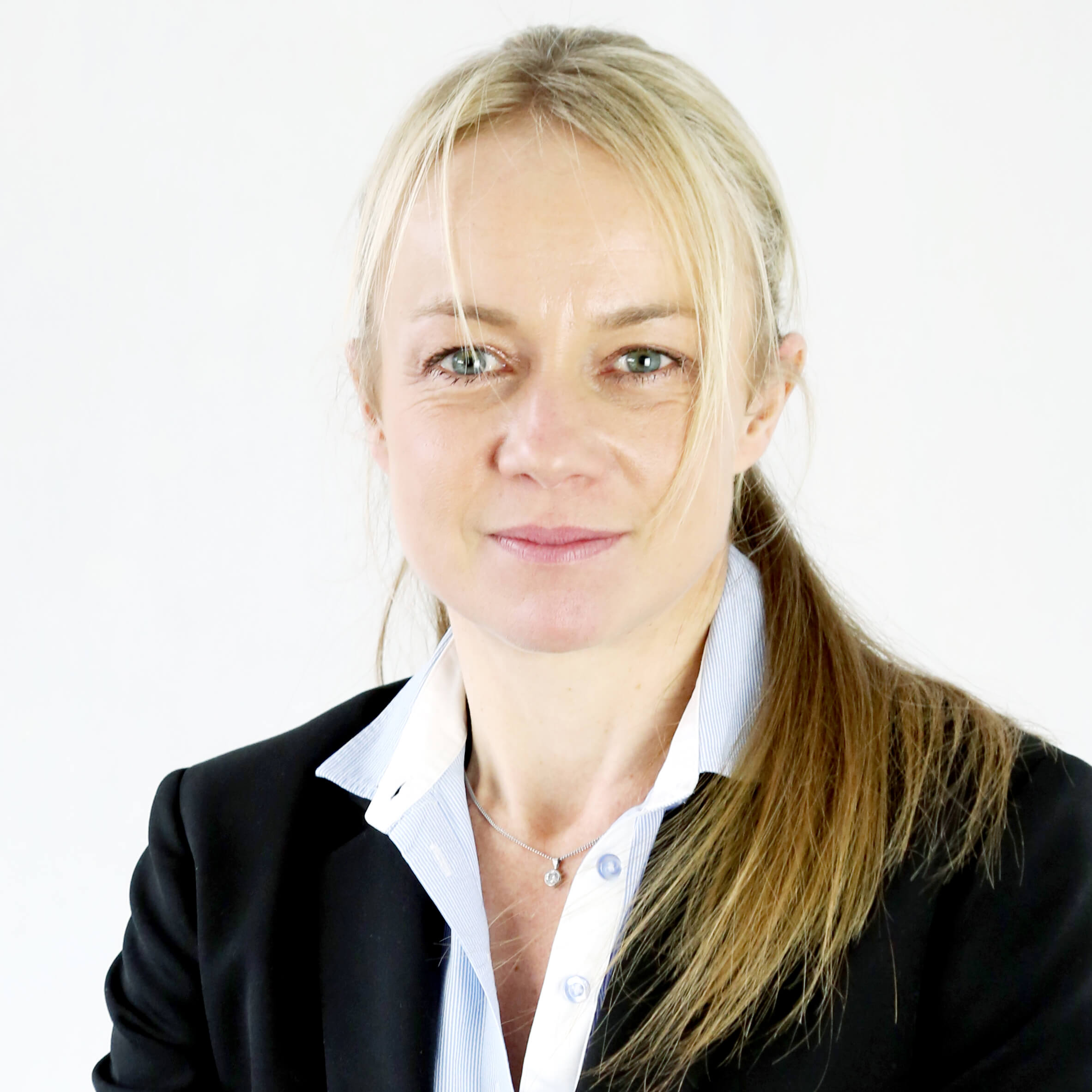 Woman with blonde hair in a black blazer and white shirt.