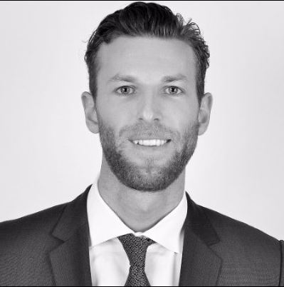 Portrait of a man in a suit and tie smiling.