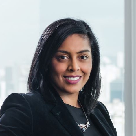 Smiling woman in a black blazer by a window