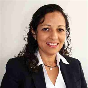 Smiling woman with curly hair in business attire.