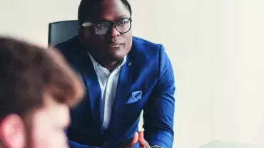 Réunion d'affaires avec un homme concentré en costume bleu.