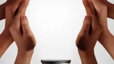 Multiple hands creating a shape around a small dish.