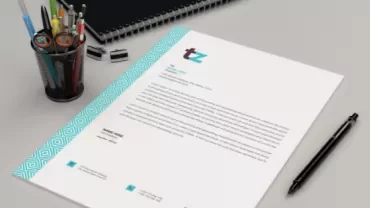 Mockup of a letter on a desk with pens and a notebook.