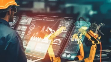 Engineer analyzes robotic arm performance on a digital screen.