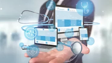 Digital healthcare icons over a hand and devices.