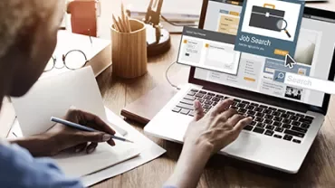 Personne utilisant un ordinateur portable pour rechercher un emploi.