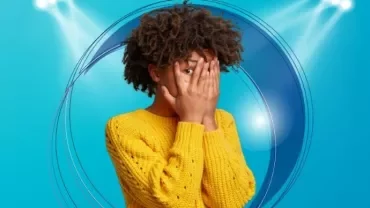 Personne en pull jaune avec les mains sur le visage sur un fond bleu.