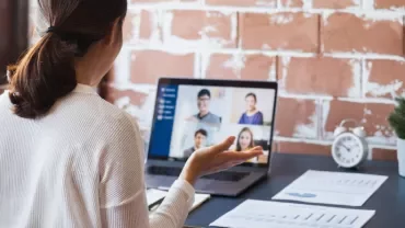 Woman engaging in a video conference call on a laptop.