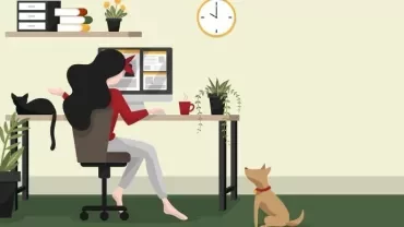 Woman working at a desk with plants, cat, and dog nearby.