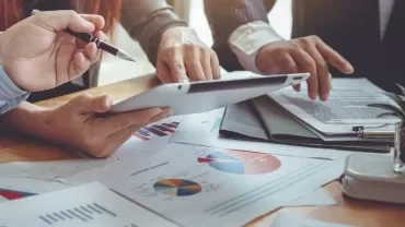 Business team reviewing charts on a tablet.