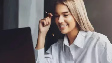 Woman smiling while using a laptop