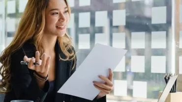 Woman smiling while holding a document in an office