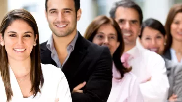 A group of smiling professionals standing in a line.
