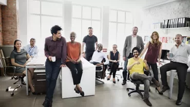 A diverse group of people smiling in a modern office.