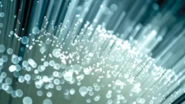 Close-up of glowing fiber optic cables with a blue background.