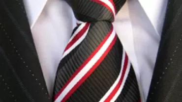 Close-up of a black, white, and red striped necktie with a suit.