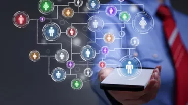 Personne tenant une tablette avec des icônes de personnes connectées par des lignes.