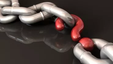 A metal chain with one red distorted link.
