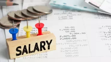 Bloc avec des épingles marqué 'Salaire' sur des documents financiers.