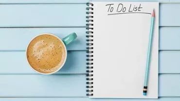 Notepad with 'To Do List' beside a coffee on a blue table.