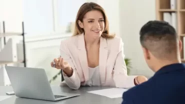 Two people having a conversation in an office setting.