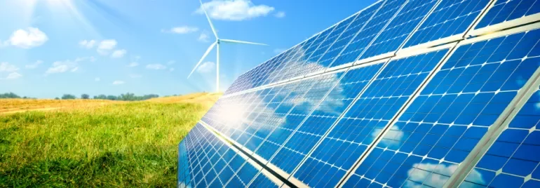 Solar panels and a wind turbine in sunny field