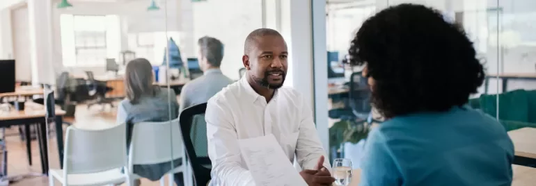 Two people having a discussion in a modern office setting.