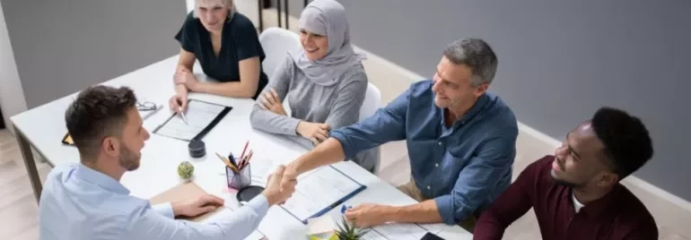 Diverse group in a meeting room shaking hands