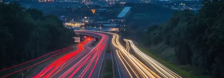 A highway at night with light trails from cars.
