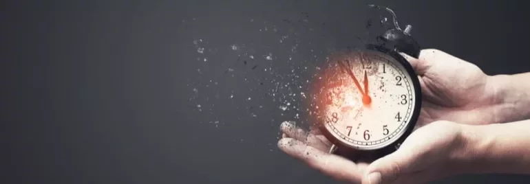 Alarm clock disintegrating in hands, symbolizing time fading.