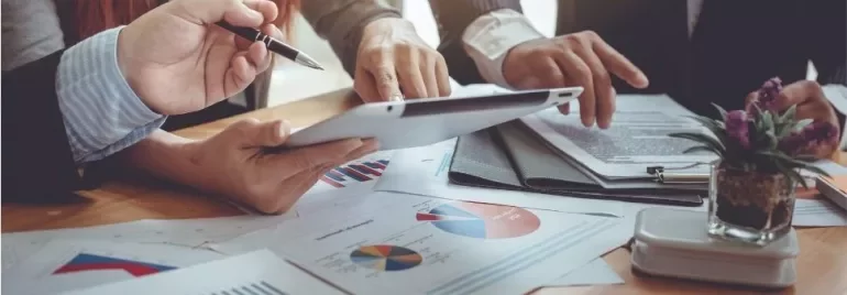 Business team reviewing charts on a tablet.