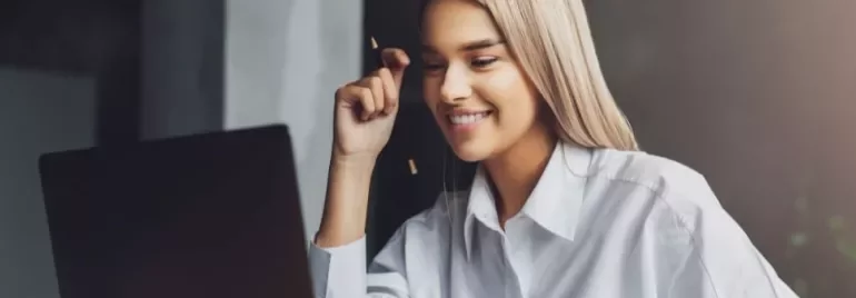 Woman smiling while using a laptop