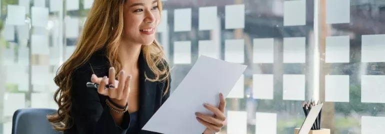 Woman smiling while holding a document in an office