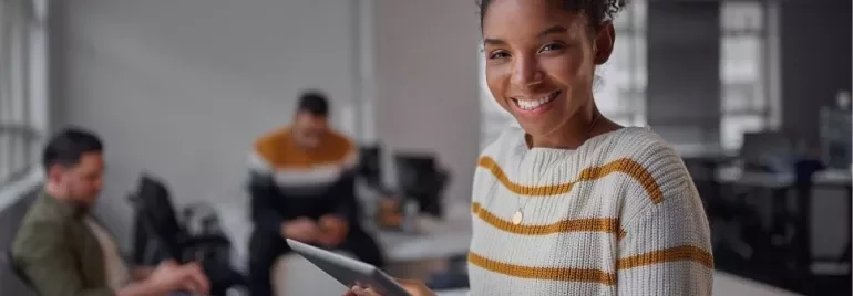Smiling woman holding a tablet in an office