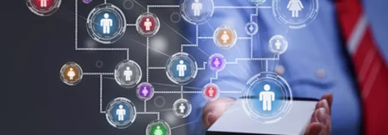 Personne tenant une tablette avec des icônes de personnes connectées par des lignes.