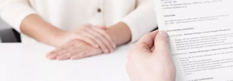 Close-up of an interview with a person holding a resume.
