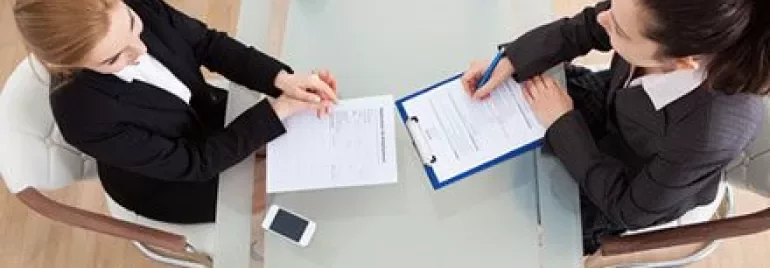 Deux personnes à une table discutant de documents.