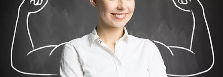 Confident woman with drawn muscular arms on a chalkboard