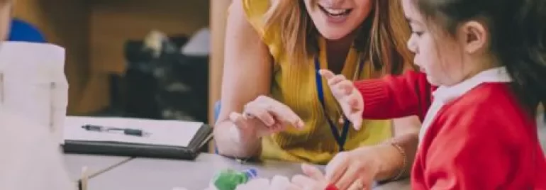 Teacher and child engaging in a fun learning activity with a toy