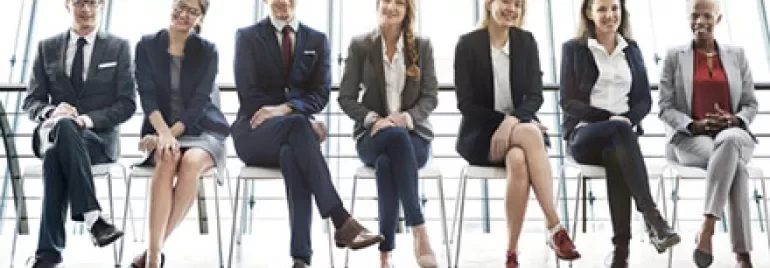 Business professionals seated in a row, smiling.