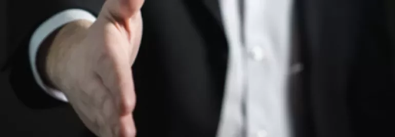 Close-up of a person reaching out for a handshake.