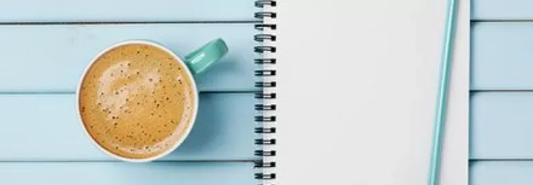 Notepad with 'To Do List' beside a coffee on a blue table.