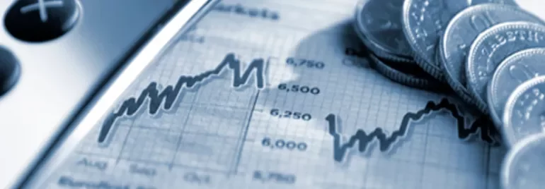 Calculator and coins on a financial graph.