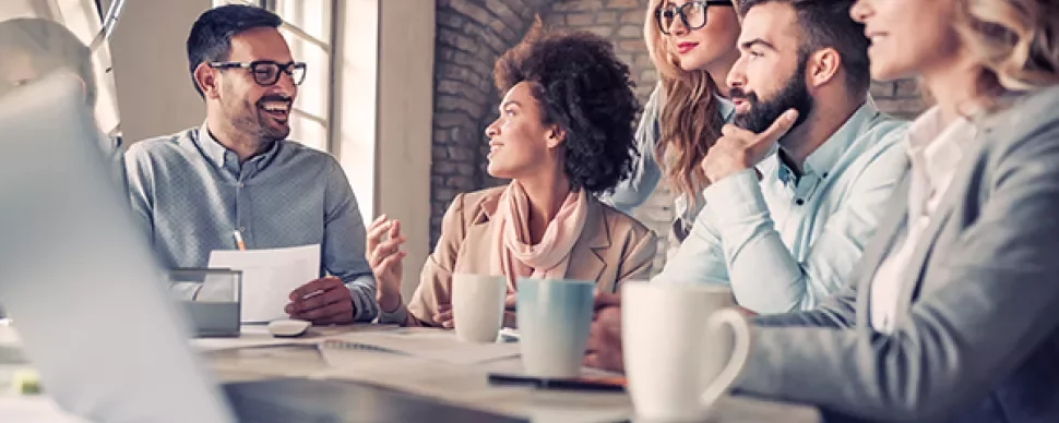 A group of people having a lively discussion in a modern office setting.