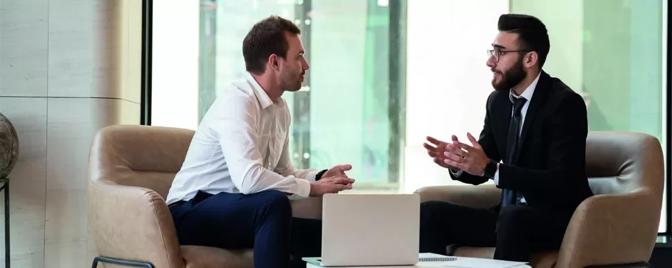 Two men having a discussion in a modern office setting.