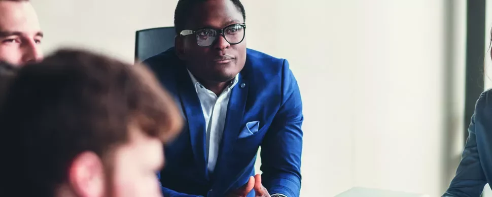 Business meeting with a focused man in a blue suit.