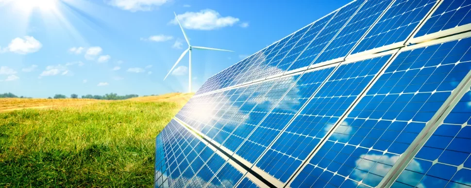 Solar panels and a wind turbine in sunny field