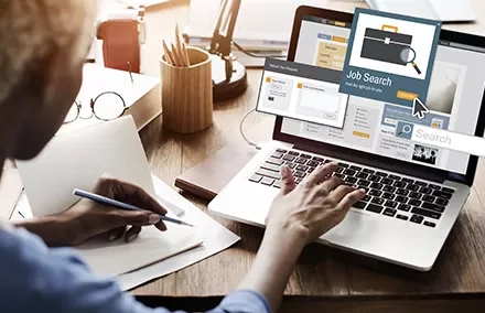 Person using a laptop for job searching.