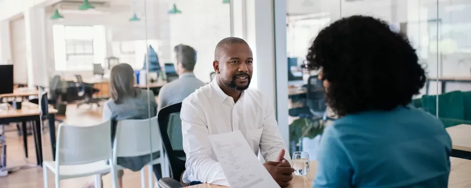 Two people having a discussion in a modern office setting.