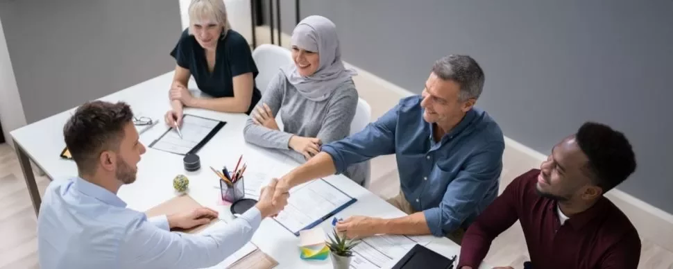 Diverse group in a meeting room shaking hands